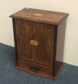 An Edwardian oak smoker's companion with fitted in