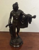 A stylish bronzed figure of a semi-naked man on ci