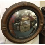 A circular gilt convex mirror with scroll decorati