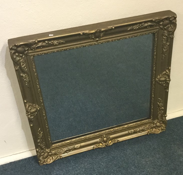 A rectangular gilt framed mirror with scroll decor