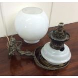 An unusual wall mountable brass oil lamp decorated
