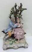 A large porcelain figure of a romantic couple bene