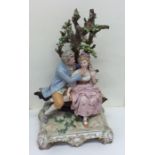 A large porcelain figure of a romantic couple bene