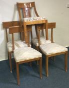 A set of four maple chairs on spreading supports t