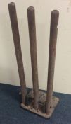 A set of training cricket stumps on cast iron base