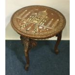 A circular Indian ivory inlaid table on three matc