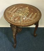 A circular Indian ivory inlaid table on three matc