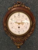 A brass mounted Dutch wall clock with white enamel