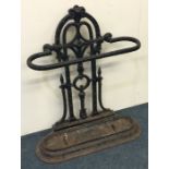 A large wrought iron stick stand decorated with sc