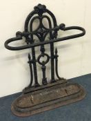A large wrought iron stick stand decorated with sc