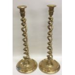 A tall massive pair of brass candlesticks of barle