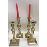 A pair of Antique brass square based candlesticks