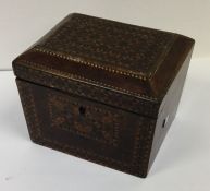 A parquetry tea caddy of shaped form with fitted i