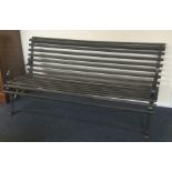 A large wrought iron slat back garden bench. Est.