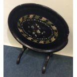 A papier-mâché and MOP inlaid tilt top table. Est.