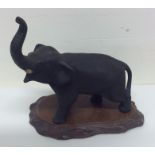 A cast bronze figure of an elephant on wooden base