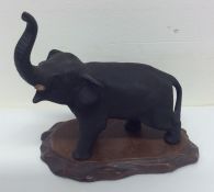 A cast bronze figure of an elephant on wooden base