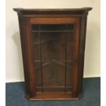 A late Georgian mahogany corner cupboard with beve