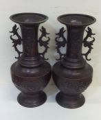 A pair of tall Japanese bronze vases with floral d