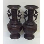 A pair of tall Japanese bronze vases with floral d