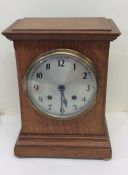 An oak cased mantle clock with silvered dial. Est.