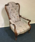 A Victorian scroll decorated armchair with floral