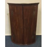 A Georgian mahogany corner cabinet of dome form wi