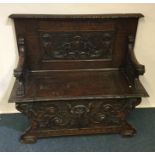 A good quality walnut carved settle with hinged fr