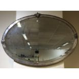 A stylish oval silver plated wall mirror with ram