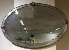 A stylish oval silver plated wall mirror with ram