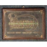 A rectangular brass engineer's plaque on wooden su