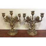 A pair of brass candelabra decorated with shells t