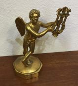 An attractive gilt model of a winged musician on s