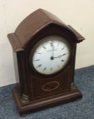 An Edwardian inlaid mantle clock on brass bun feet
