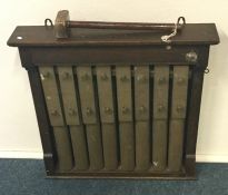 An unusual set of brass mounted wall chimes in oak