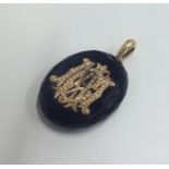 A large onyx and gold mourning pendant with pearl