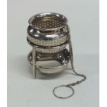 An American silver tea strainer on stand of taperi