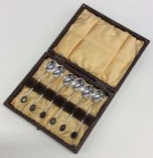 A cased set of six bean top silver coffee spoons.