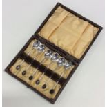 A cased set of six bean top silver coffee spoons.