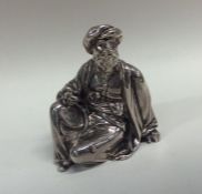 A Victorian silver figure of a seated man in long