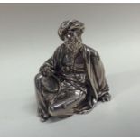 A Victorian silver figure of a seated man in long