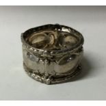 A Continental silver napkin ring with embossed dec