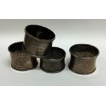 A group of four silver napkin rings. Various dates