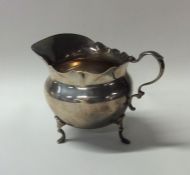 A small silver cream jug with card cut rim. London