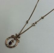 A gold mounted circular pendant with loop top on f