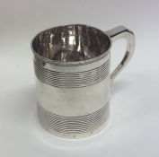A Georgian silver mug with tapering reeded sides.