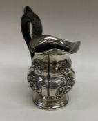 An Austrian silver cream jug with embossed decorat