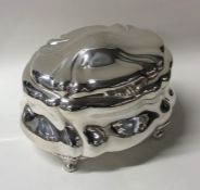 A Continental silver caddy of swirl form to scroll