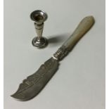 A small silver candlestick together with a butter