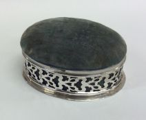 An oval silver pin cushion / jewellery box with sc